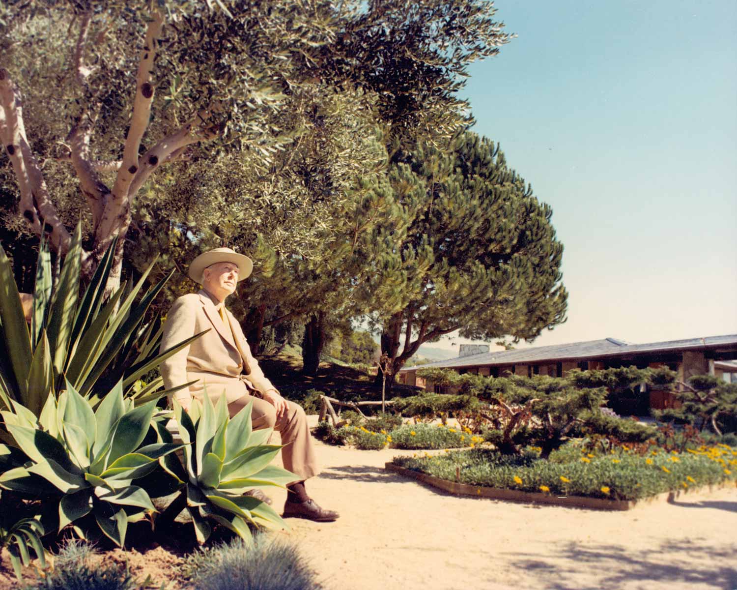 Architect Lloyd Wright sitting in the chapel rose garden, circa 1974